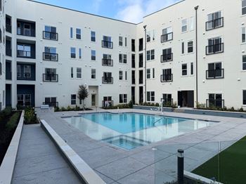 A large white building with a pool in front.